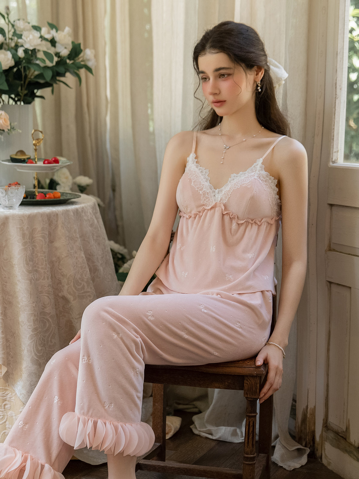 Pink lace V neck camisole and ruffle cuff pajama pants seated front view