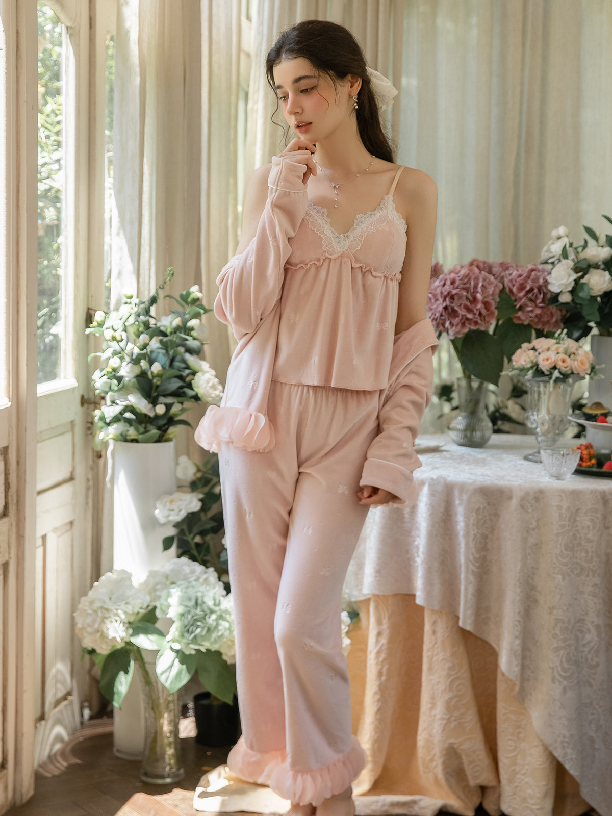 Pink ruffle hem sleep jacket worn open over coordinating camisole and pants